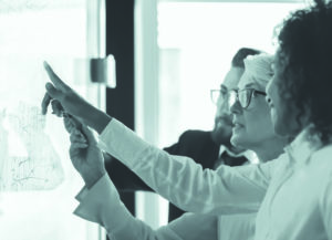 three teachers working together at a white board